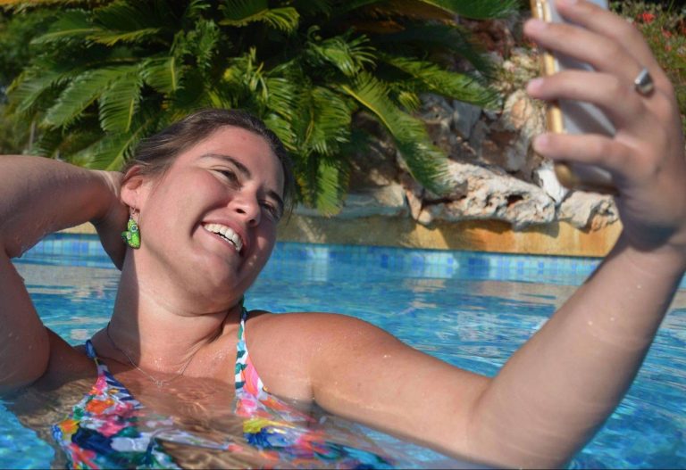 Mulher na piscina tirando selfie