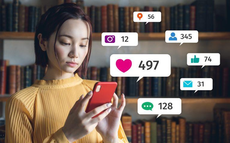 mulher asiática vendo os resultados nas redes sociais