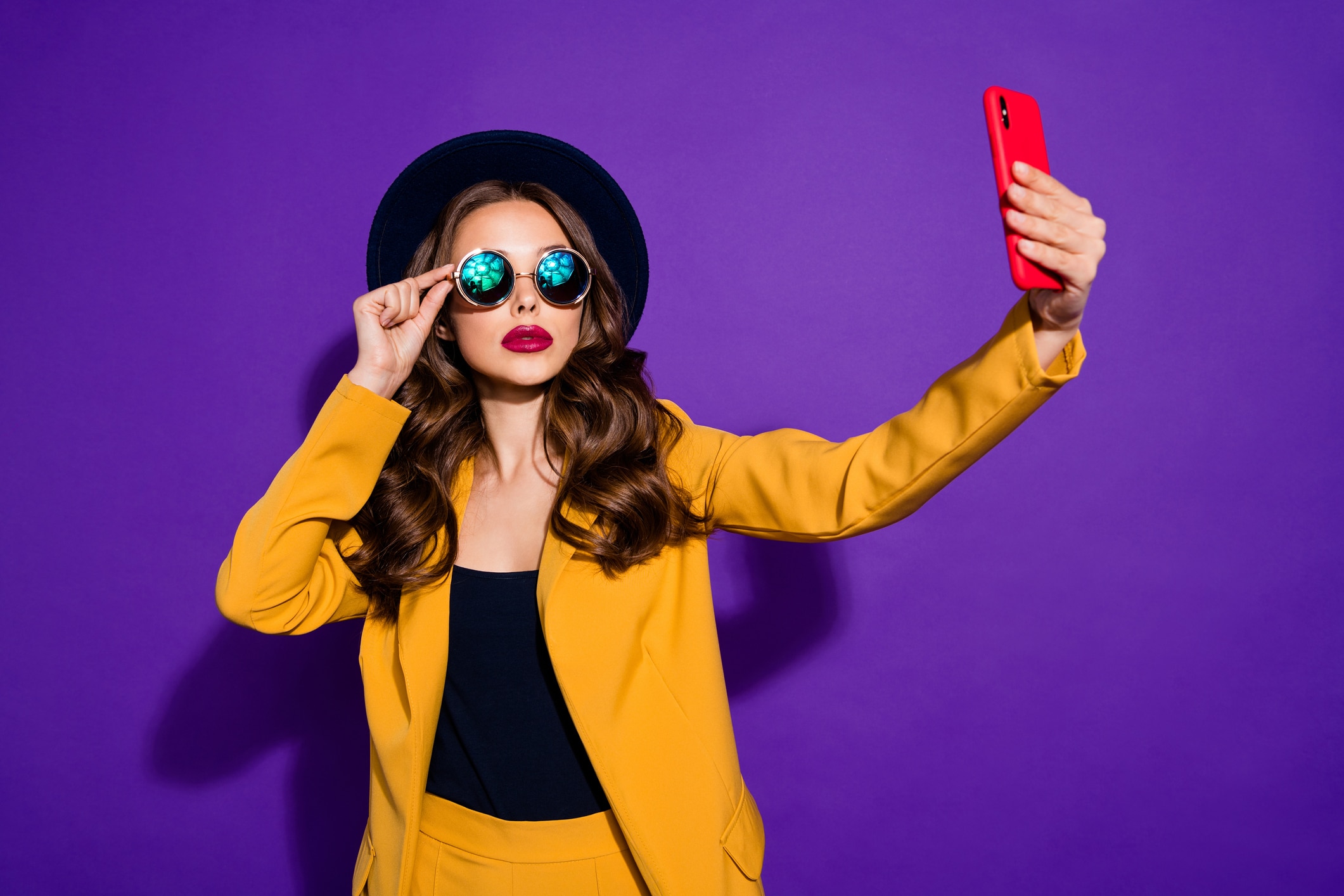 Photo of confident lady holding hands telephone making selfies wear specs yellow costume isolated purple background